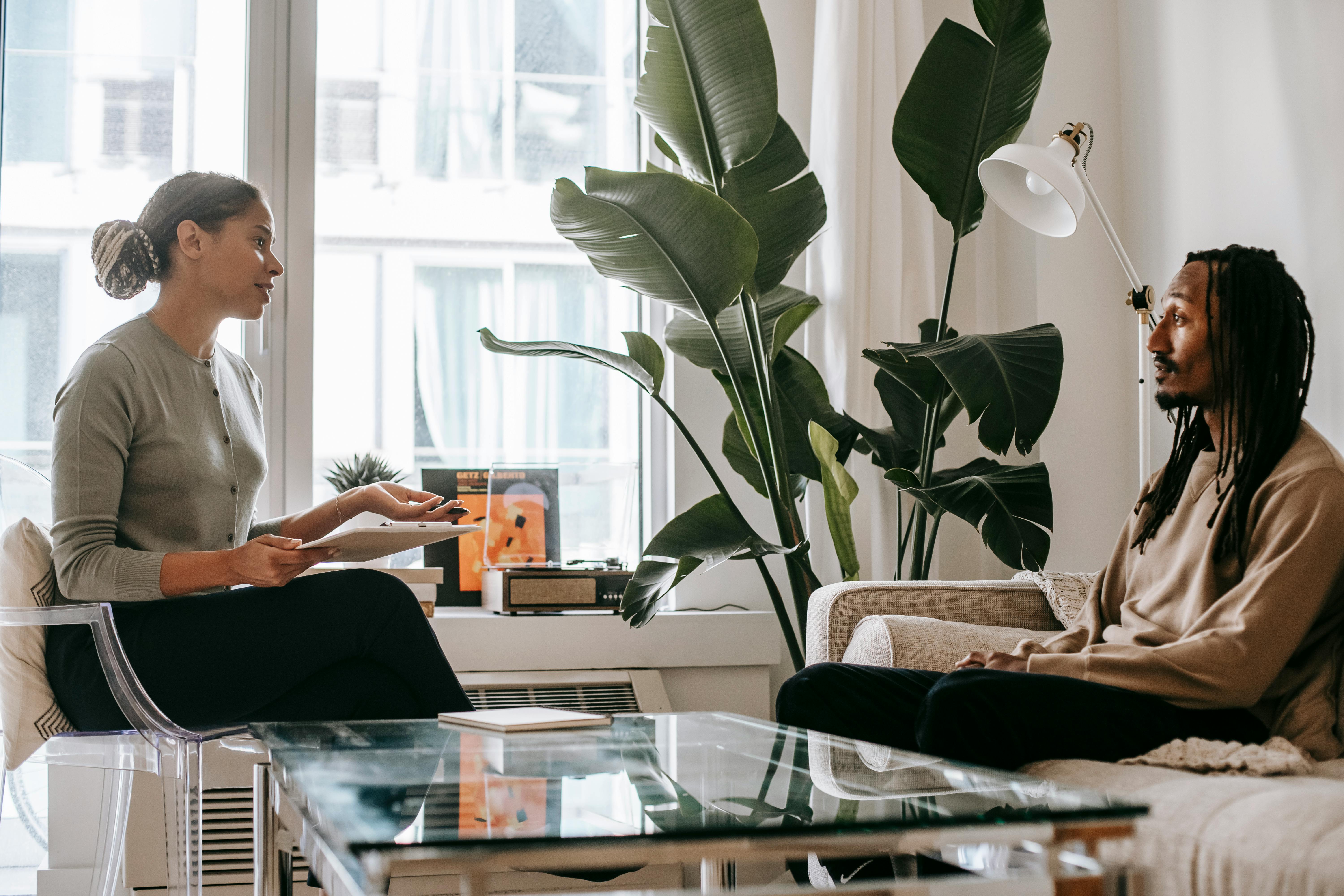 A supportive counselling session between a therapist and a Black male client.